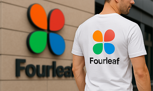 Man bär en personlig vit t-shirt med färgglad ”Fourleaf”-logotyp som matchar branding på vägg i bakgrunden.