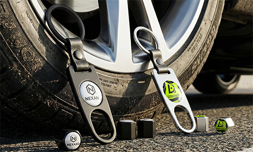 Branded tire valve caps with custom logos and matching keychains shown next to vehicle wheel