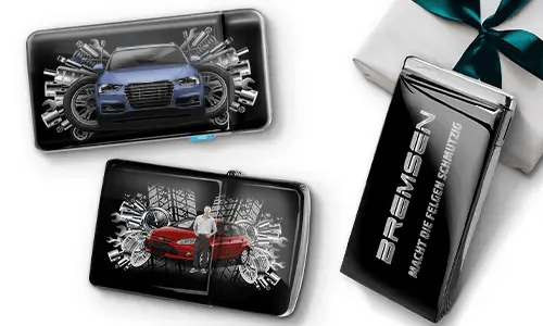 Drei elegante schwarze Geldbörsen mit Bildern von Autos und Zahnrädern, platziert neben einer Geschenkbox. Auf einer steht „Bremsen“. Das Design ist dynamisch und modern.