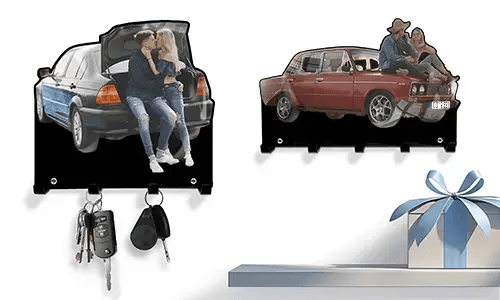 Zwei personalisierte Schlüsselhalter: Paar im Kofferraum eines blau-schwarzen Autos, Paar auf der Motorhaube eines roten Oldtimers
