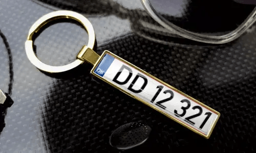 Porte-clés doré style plaque d’immatriculation avec gravure dans un cadre métallique poli