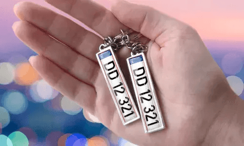 Llaveros con placa personalizada y números personalizados, sostenidos en la mano
