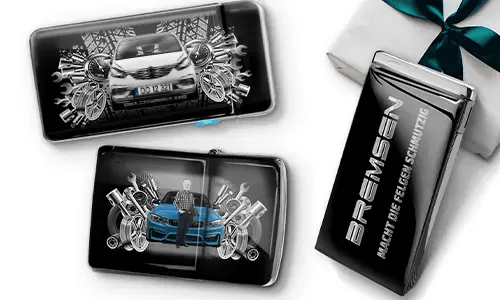 Three automotive-themed items featuring car illustrations and machinery motifs, arranged with a gift box tied with a green ribbon on the side.