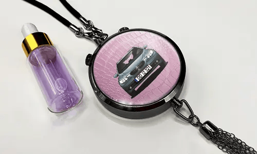Pendant with pink background and white sports car, next to purple dropper bottle with gold cap