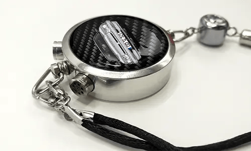 Round car key fob with carbon fiber face, buttons labeled LOCK and UNLOCK, braided black cord attached