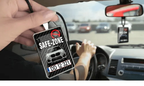 Auto-Safezone-Anhänger mit Carbon Hintergrund in der Hand Auto-Schutzraum-Anhänger