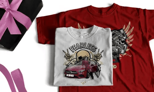 Two T-shirts, one white with FEARLESS, skull, halo, hand signs, red car; one red with winged skull