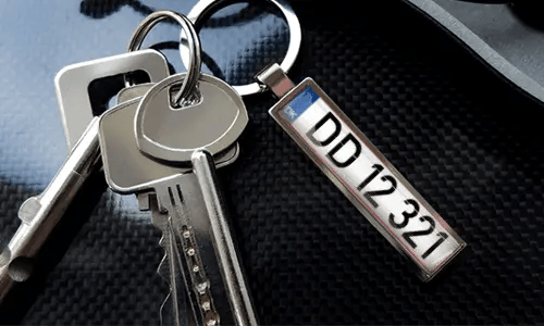 Porte-clés avec pendentif illustrant une voiture et anneau en métal