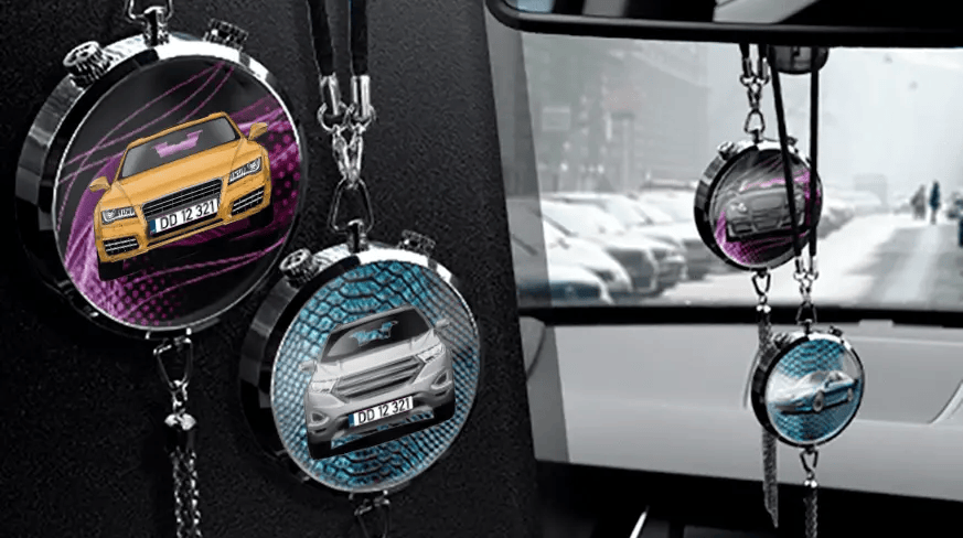 Two circular car air fresheners hanging from rearview mirror: left with black car, right with blue car